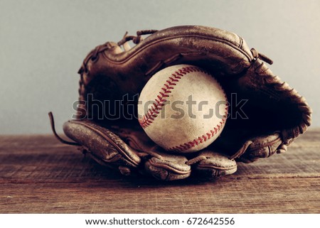 old Baseball and glove on wood background with filter effect retro vintage style