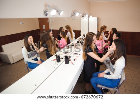 Make-up artist doing professional make-up of young woman