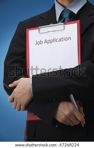 businessman holding resume and a pen