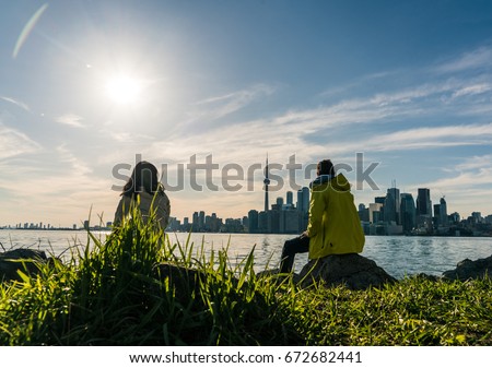 A man and woman looking at Toronto skyline from Toronto islands.