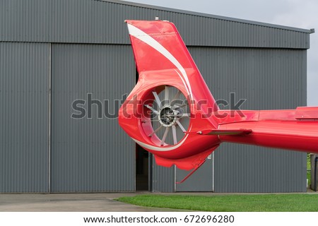 close up the tail rotor of a red helicopter.
The tail rotor is a smaller rotor mounted so that it rotates vertically or
 near-vertically at the end of the tail of a traditional helicopter. Royalty-Free Stock Photo #672696280