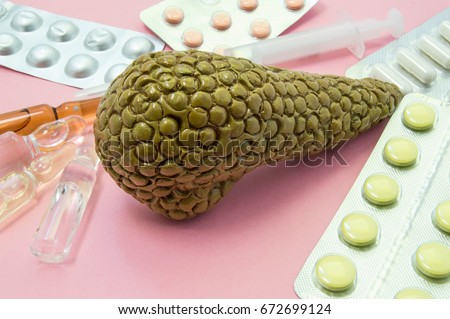 Pancreas treatment concept photo. Figure of pancreas surrounded by pills, medications, medicine vials with syringe, symbolizing treatment, prevention and protection of pancreas gland from diseases 