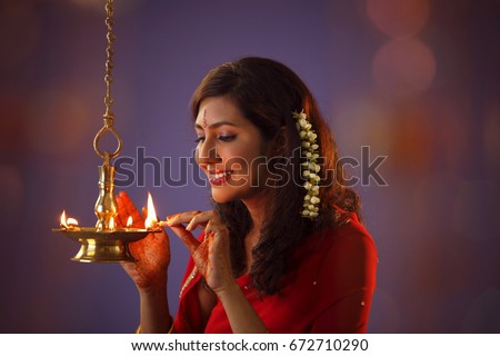 woman devotee lights  lamps as she celebrate 'deepavali' Royalty-Free Stock Photo #672710290