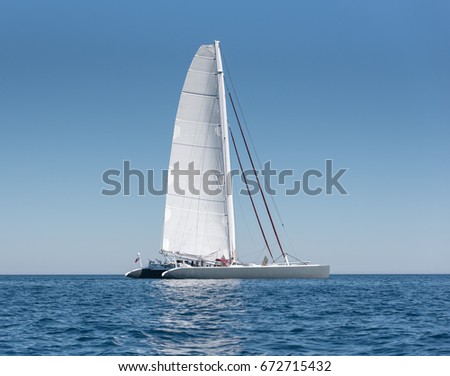 A single catamaran in the open sea. Royalty-Free Stock Photo #672715432