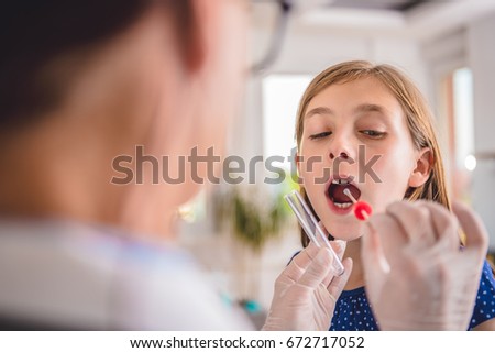 Female pediatrician using a swab to take a sample from a patient's throat Royalty-Free Stock Photo #672717052