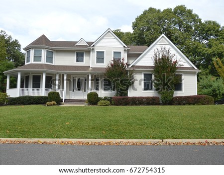 Real Estate For sale sign Beautiful white McMansion home with flowers USA
