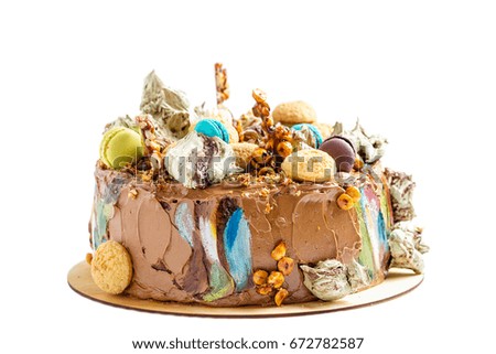 Chocolate cream cake decorated with colorful confectionery and pastries on white background. Mousse cake with decoration