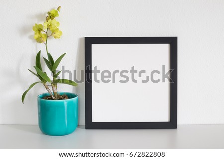 mock up square frame photo with yellow orchid flower in room