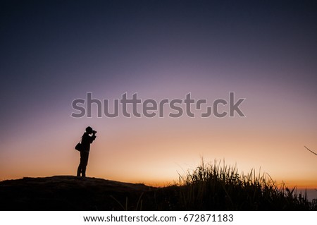 silhouette of photographer taking picture during sunset