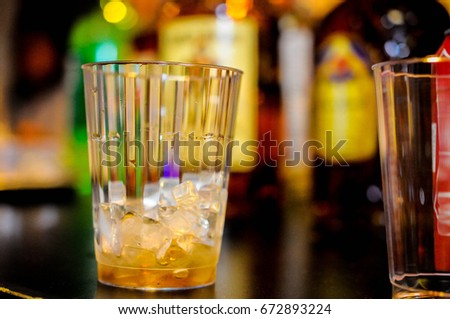 Ice cubes melt slowly in this empty cup, capping off an alcoholic beverage scene.