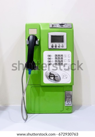 Green vintage public pay phone isolated on white background