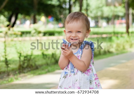 Little girl in the park on a walk is plotting a trick. Girl 1 years old.