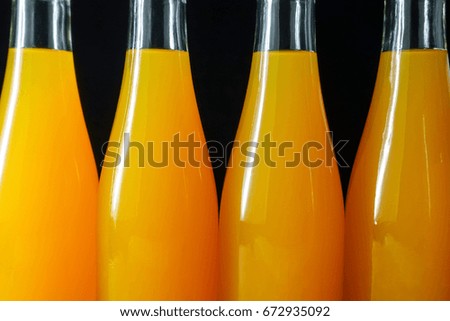 orange juice bottles on black background - closeup