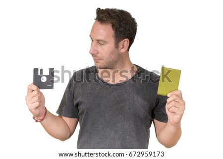 Young man wearing black t-shirt,  holding Floppy disk on right hand and holding External Hard Drive on left hand. isolated on white background.