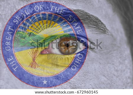 Human face and eye painted with US state seal flag of Ohio