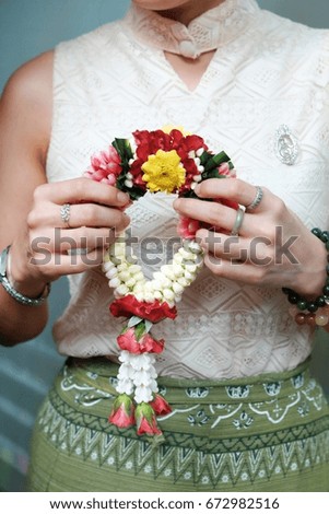 A woman is holding  beautiful jasmine garland in her hand on  special day