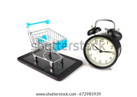 Shopping cart on tablet with an alarm clock. Online shopping concept. Online shopping is an electronic commerce which allows consumers to directly buy goods from a seller over the Internet. 