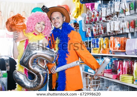 Happy couple preparing for fest and choosing funny headdresses 