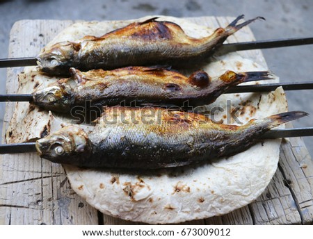 Fried fish on the grill. Delicious, unusual taste of fish from fire.