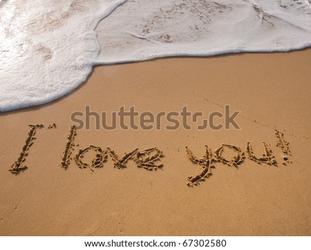 The inscription on the sand near the sea and the waves - I love you. Background.