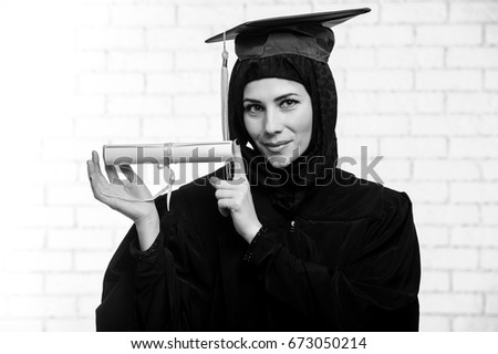Happy graduate muslim student with diploma indoor.Black and white picture.