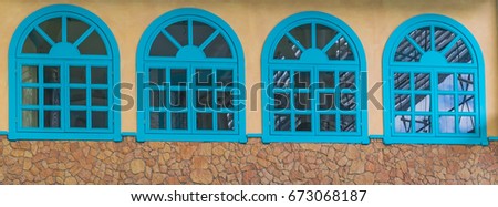 Vintage frame window frame blue color 4 channels on brown stone wall.