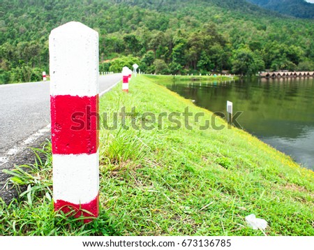 Red Traffic symbol and mountain, river in countryside area.