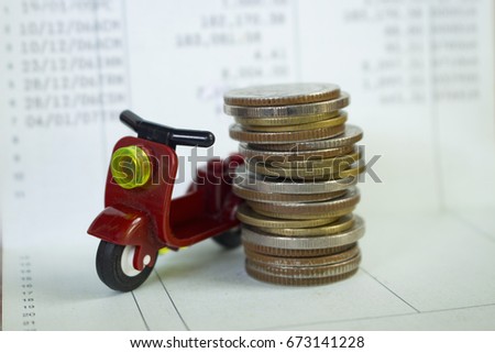 concept for money saving ,image of stack of coins with motorcycle toy and account passbook,buy or rent motorcycle.