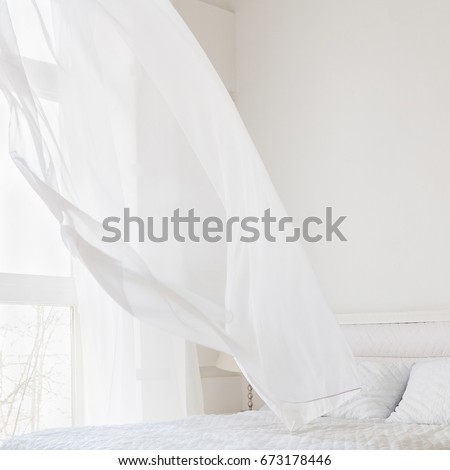 Abstract white room interior with waving curtain by fresh air Royalty-Free Stock Photo #673178446