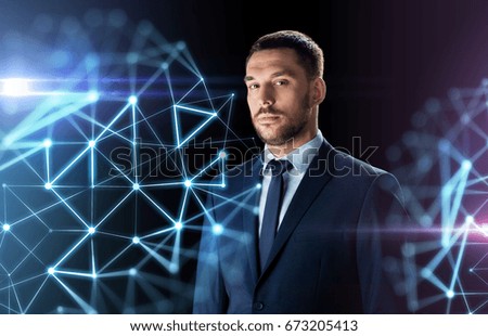 business, people and technology concept - businessman in suit over black background with low poly shape projection