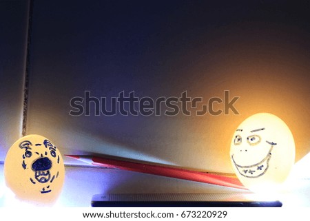  funny man face  and  afraid dog face on eggshells and red crayon on orange blue and black  background