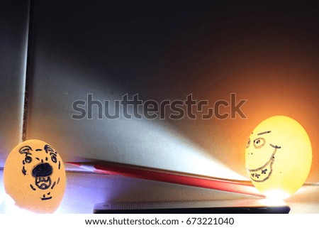  funny man face  and  afraid dog face on eggshells and red crayon on orange and black background