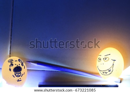  funny man face  and  afraid dog face on eggshells and red crayon on orange and blue background