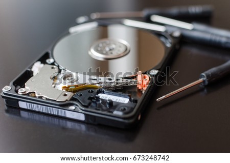 Repair of the dismantled hard drive. Hdd with mirror effect. Screwdrivers for computer repair.