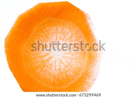 close up of a thin slice of carrot back lit with a beautiful pattern and glowing orange color
