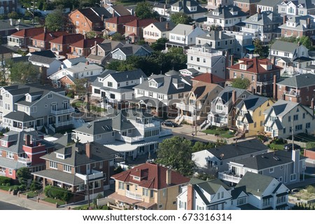 Aerial birds eye view of expensive ocean side real estate houses on bright summer day. Neighborhood of luxury beach front homes