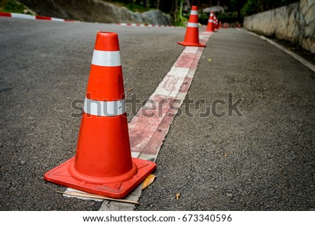Plastic orange cone on the asphalt road