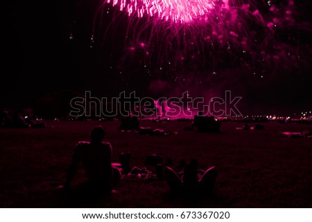 Pink fireworks with two guys watching. Pink dark silhouettes.