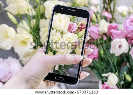 Flowers ordered online. Woman taking pictures of flowers by her smartphone. 