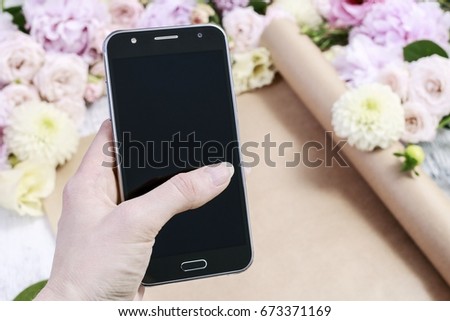 Flowers ordered online. Woman taking pictures of flowers by her smartphone. 