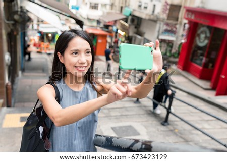 Young woman travel in Pottinger Street and taking photo