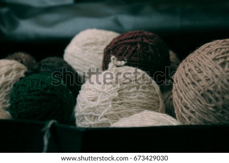 skeins of woolen yarn in pastel shades in a wooden background/felted wool bird