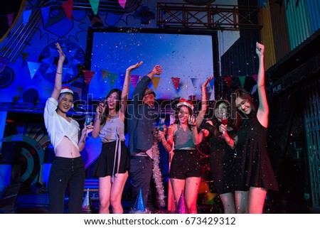 Group of happy friends in party at nightclub,Happy young friends raising their arms and having fun among the colorful in a outdoors party, Friendship and celebrations concept, party, Age 20-30 years.