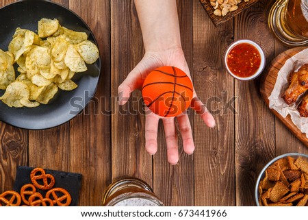 Picture of table and chips, crackers, nuts, beer, hand with volleyball