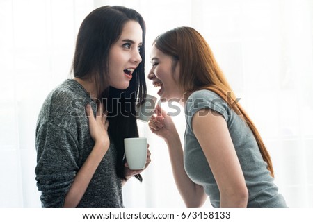Beautiful young asian women gossiping and whispering to ear at home, communication concept