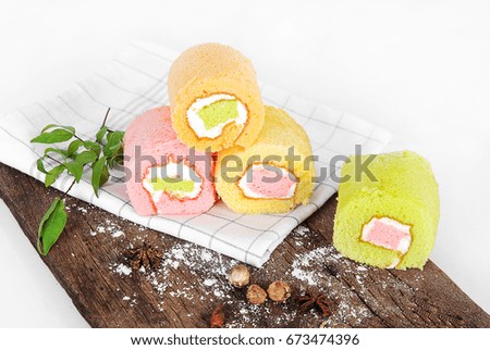set of pieces cake roll strawberry orange green tea and vanilla butter cream taste,dessert and homemade bakery on wooden tray isolated white background,food flat lay picture 