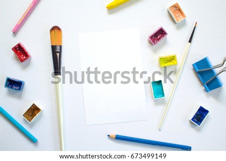 White paper notepad and drawing art supplies. Colorful artistic flat lay on white background. Creative hobby or craft banner template with text place. Art workplace top view. Handmade studio mockup