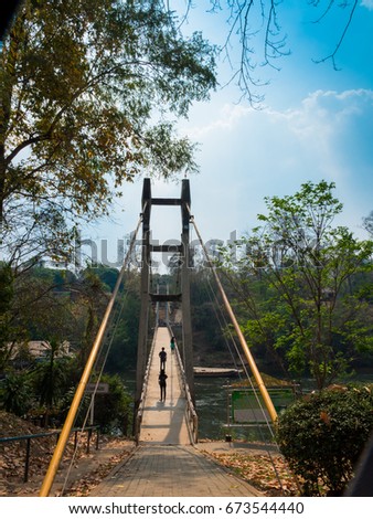 travel around Sai Yok Yai waterfall  in Kanchanaburi province.when acrosing the  suspension bridge above Kwai Yai  river will see rafts and floating resort on the boat side of river