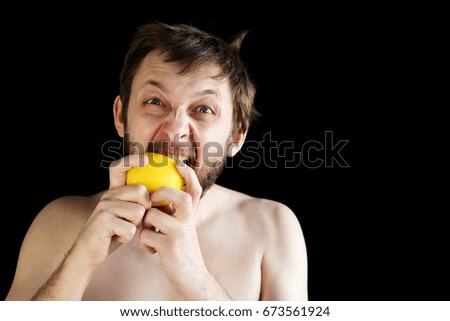 Dishevelled man eating a lemon