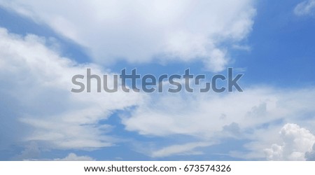 The blue sky with scattered clouds.